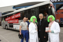 Landesrat Walter Steidl vor dem Männergesundheits-Bus. Im Hintergrund vier Mitarbeiter der Mayer & Co Beschläge GmbH, die sich gerade auf den Weg zu ihrem "Boxenstopp" in den Bus machen.