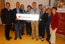 Die Mitglieder des Gesundheitsarbeitskreises nehmen die Ortstafel entgegen. v.l.n.r.: Mag. Karl Schwaiger, Bürgermeister Sebastian Pirnbacher, Margret Hirschegger MAS, Irmgard Moser, Rudolf Pirnbacher, Johanna Vötter, Alfreda Krenn, Traudi Öhlinger und Mag. Maria Pramhas von AVOS.