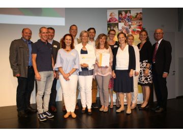 KG Vog lau (Abtenau), 1.R.v.l.: Dr. Holger Förster, AVOS, Maud Bukovics, AVOS, Herta Schefbänker, GBA, Ltg., Barbara Schmöller, vorm. Ltg., Karin Lanzinger, Kathrin Brandauer, Eva Pfister; 2. R.v.l.: Christian Eder, Vizebgm., Ing. Günther Quehenberger, Amtsleiter, Dr. Harald Seiss, SGKK, Labg. Ing. Johann Schnitzhofer, Bgm., Mag. Angelika Bukovski MIM, GF AVOS, LH-Stv. Dr. Christian Stöckl